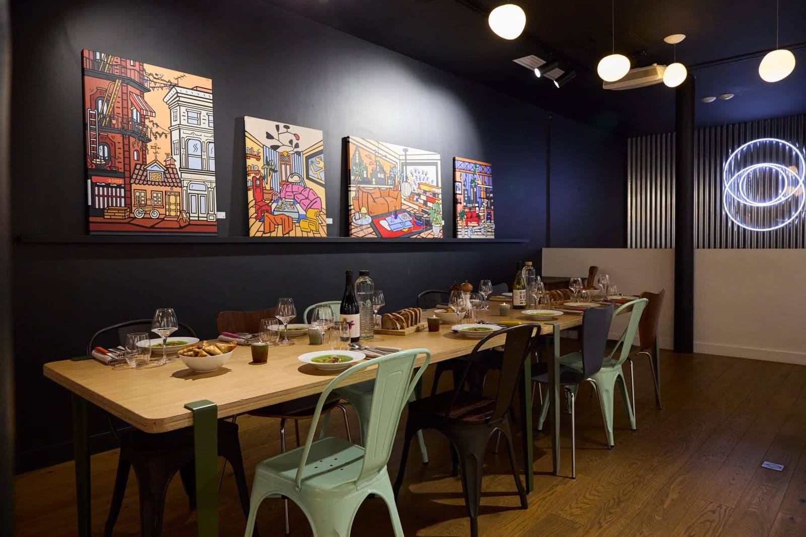The long table of Le 3ème Cercle set beneath the exhibited artworks, Paris 11